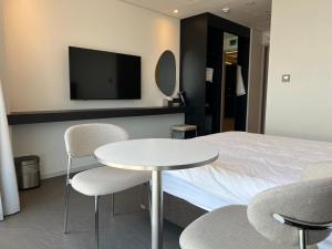 a hotel room with a bed and a table and chairs at 코브스테이 해운대 in Busan +13 photos