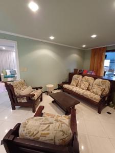 a living room with a couch and chairs and a table at Casa no Centro de Pomerode - Pousada in Pomerode