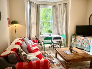 a living room with a couch and a table at Peaceful park side apartment in Hastings
