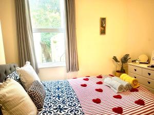 une chambre avec un lit avec des cœurs dessus dans l'établissement Peaceful park side apartment, à Hastings