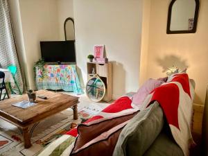 un salon avec un canapé et une table dans l'établissement Peaceful park side apartment, à Hastings 9 autres photos