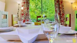 un tavolo con bicchieri e piatti su un tavolo di Chalet Flore a Murol