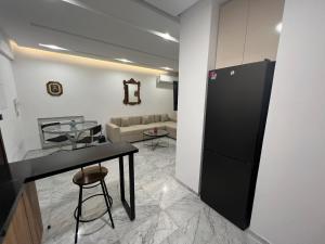 a kitchen with a glass table and a black refrigerator at la soukra cozy apartment in La Soukra