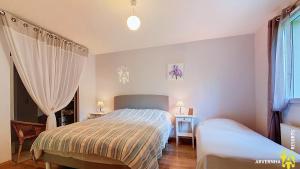 una piccola camera da letto con un letto e una finestra di Chalet Flore a Murol