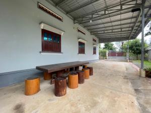 a group of wooden benches sitting under a building at Homestay342 in Phumĭ Svay Chh'êh
