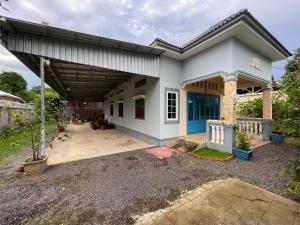 a small white house with a garage at Homestay342 in Phumĭ Svay Chh'êh