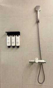 a bathroom with a shower head and two hair dryers at 코브스테이 해운대 in Busan