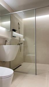 a bathroom with a glass shower and a toilet at 코브스테이 해운대 in Busan