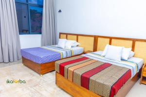 two beds in a hotel room at Ikamba-Lakeview Apartment in Kampala