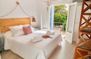 a bedroom with a white bed with towels on it at Casa Codol in Illes Balears
