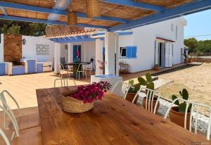 a wooden table with a vase of flowers on a patio at Casa Codol in Illes Balears