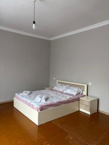 a bed in a room with a white wall at Gyumri Home in Gyumri