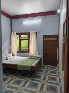 a bedroom with a bed and a window and a door at Sirful Homestay in Pedong