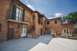 a large brick building with a driveway in front of it at La Lisa in Foiano della Chiana