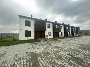 a building with a cobblestone street in front of it at ZIBO APARTMENTS LESKO Nowoczesne apartamenty z jacuzzi i widokiem na Bieszczady in Lesko