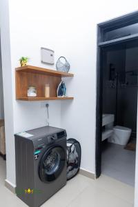 a washing machine in a room with a toilet at Ikamba-Lakeview Apartment in Kampala
