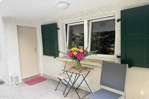 a vase of flowers sitting on a table next to a window at CHL Stay apartment One-Bedroom Apartment Steps from Luxembourg Hospital-Private Garden Included in Luxembourg +2 photos