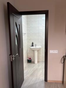 a bathroom with a sink and a door leading to a bathroom at Gyumri Home in Gyumri +11 photos
