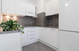 una cocina blanca con armarios blancos y una maceta en Fellini Suite - Sea View, en Rímini