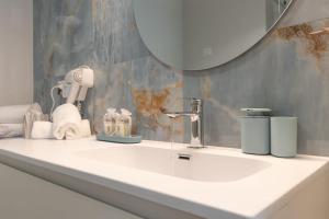 Un baño con un lavabo blanco y un espejo. en Fellini Suite - Sea View, en Rímini 7 fotos más