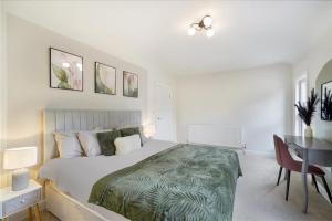 ベッドフォードにあるStylis 5BR Bedford Home, Sleeps 7,Ideal for Contractors Stay, Near Transportのベッドとテーブルと机のある寝室