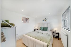 a white bedroom with a bed and a window at Stylish 5BR Bedford Home, Sleeps 7,Perfect for Contractors Deal, Near Transport in Bedford