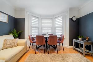a living room with a table and chairs at Stylish 5BR Bedford Home, Sleeps 7,Perfect for Contractors Deal, Near Transport in Bedford