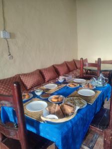 a blue table with plates of food on it at Sahara Sands Hotel in Merzouga +57 photos