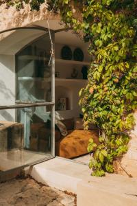 a room with a bed and a glass window at Santanyí's Hidden Gem - a Townhouse with Soul in Santanyi