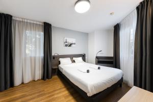 ein Schlafzimmer mit einem großen weißen Bett vor einem Fenster in der Unterkunft Cozy Marne - 2 people - Paris in Nogent-sur-Marne