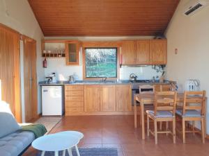 a kitchen with wooden cabinets and a table and chairs at Quinta de Natureza in Nabais