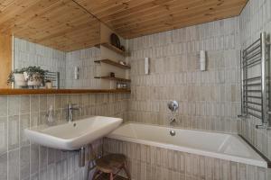 a bathroom with a sink and a bath tub at The Hideaway at Yew Trees, Ullswater in Watermillock +43 photos