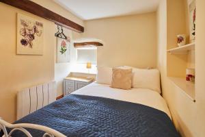 ein Schlafzimmer mit einem Bett mit einer blauen Decke in der Unterkunft Host & Stay - Dairy Cottages in Masham