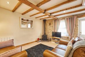ein Wohnzimmer mit Sofa und Fernseher in der Unterkunft Host & Stay - Dairy Cottages in Masham + 13 Fotos