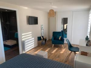 sypialnia z niebieskim krzesłem i salon w obiekcie Domaine de Jarentin - Loire 42 w mieście Saint-Marcel-de-Félines