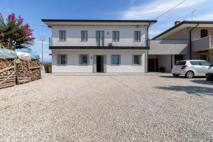 a white house with a car parked in a driveway at Bru&Lui sweet house in Cittadella