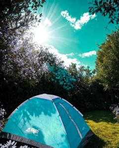 a blue tent in a field with the sun in the sky at KA Tent 