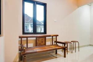 eine Bank und zwei Hocker in einem Zimmer mit Fenster in der Unterkunft Dancenter Plain C Lake in Kedaton