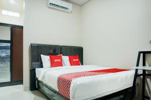 ein Schlafzimmer mit einem Bett mit roten Kissen darauf in der Unterkunft Dancenter Plain C Lake in Kedaton