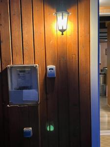 a light on a wooden wall with a light on it at Spacious Summerhouse with Hot Tub & Garden in Selfoss
