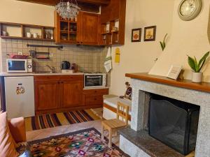a kitchen with a living room with a fireplace at to spitaki in Arachova