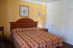 a bedroom with a bed with a colorful bedspread at Seaside Inn Motel in Port Hueneme