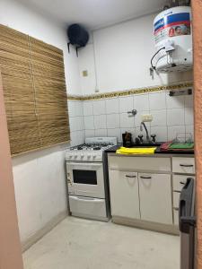 a kitchen with a stove and a sink at Departamento Monoambiente céntrico en Tandil in Tandil
