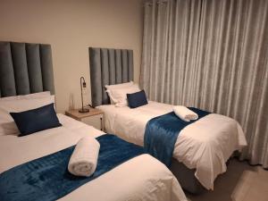 a hotel room with two beds with towels on them at Bliss Ballito Apartment in Ballito +18 photos