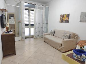 una sala de estar con un sofá y un televisor en La Casa Di Via Marzulli, en Acireale