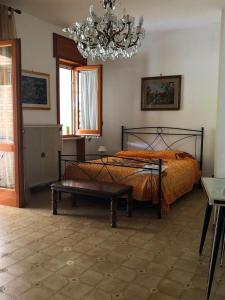 a bedroom with a bed and a chandelier at Casa Letizia Appartamento Completo in Sannicola