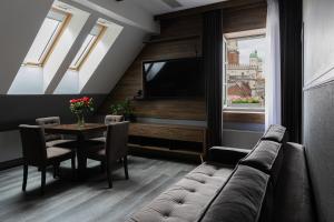 a living room with a couch and a table at RATUSZOVA Stary Rynek Old Market PREMIUM Apartments & Restaurant AD 1954 in Poznań