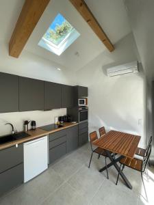 cocina con mesa, sillas y tragaluz en Maison en Provence avec terrasse privée - Fibre TV, en Lambesc 5 fotos más