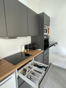 a kitchen with gray cabinets and a counter top at Maison en Provence avec terrasse privée - Fibre TV in Lambesc