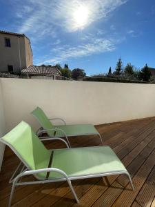 2 sillas verdes en la parte superior de una terraza de madera en Maison en Provence avec terrasse privée - Fibre TV, en Lambesc